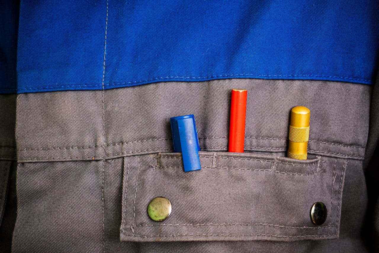 Close-up of colorful tools in a blue and gray workwear pocket.